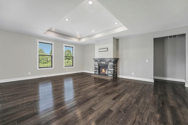 8275 Woodhaven Dr SW, Byron Center, MI 49315 - unfurnished living room with a tray ceiling, dark wood-style floors, a fireplace, and recessed lighting