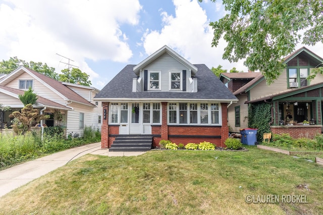 129 Dean St NE, Grand Rapids, MI 49505 - view of front facade with brick siding, a front yard, entry steps, a shingled roof, and cooling unit