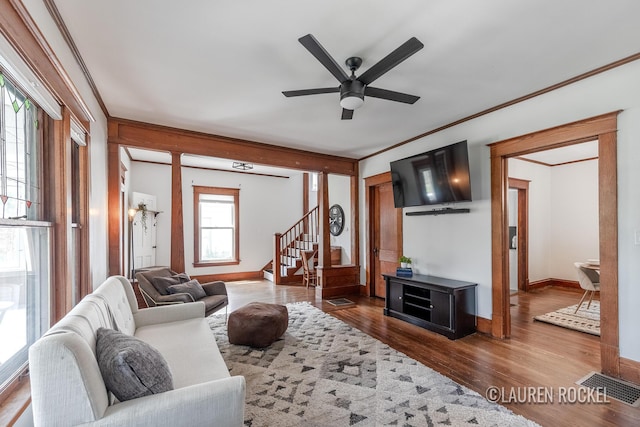 129 Dean St NE, Grand Rapids, MI 49505 - living room featuring a ceiling fan, wood finished floors, stairs, and crown molding