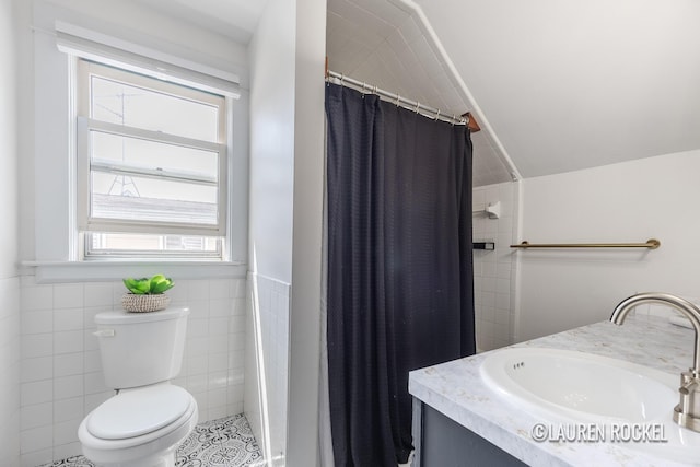 129 Dean St NE, Grand Rapids, MI 49505 - full bathroom featuring a tile shower, tile walls, vanity, lofted ceiling, and wainscoting