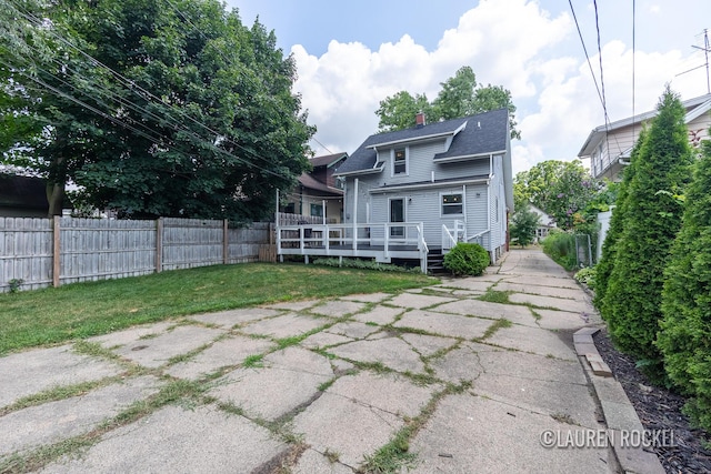 129 Dean St NE, Grand Rapids, MI 49505 - back of house featuring a chimney, a wooden deck, and a shingled roof