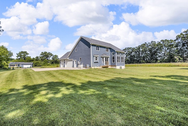 9430 Island Lake Rd, Dexter, MI 48130 - back of property featuring a lawn, driveway, and an attached garage