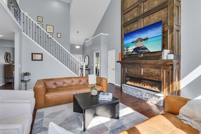 9430 Island Lake Rd, Dexter, MI 48130 - living room featuring a towering ceiling, stairway, wood finished floors, and a stone fireplace