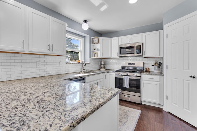 9430 Island Lake Rd, Dexter, MI 48130 - kitchen featuring appliances with stainless steel finishes, white cabinets, light stone counters, and backsplash