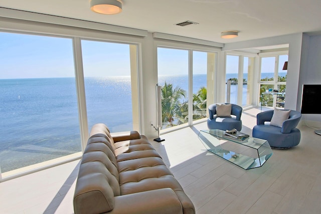 living room with light hardwood / wood-style flooring and a water view