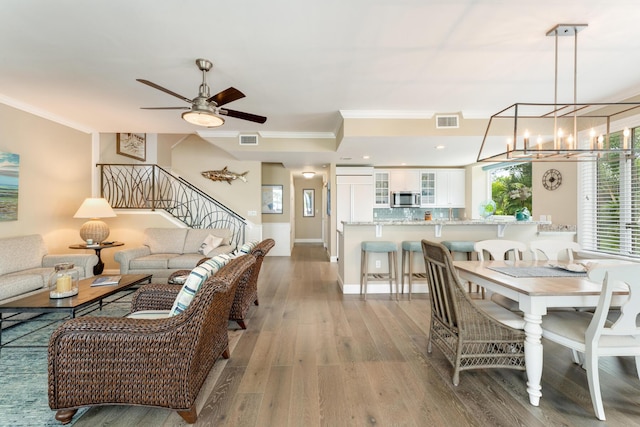 81250 Overseas Hwy Unit 1, Islamorada, FL 33036 - dining area featuring ornamental molding, wood finished floors, a ceiling fan, stairs, and a chandelier