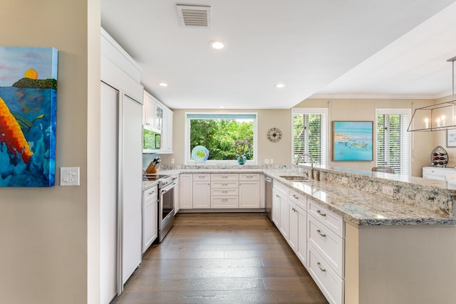 81250 Overseas Hwy Unit 1, Islamorada, FL 33036 - kitchen with stainless steel appliances, white cabinetry, light stone countertops, a peninsula, and dark wood-style flooring