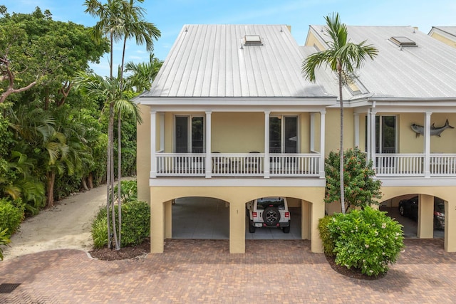 81250 Overseas Hwy Unit 1, Islamorada, FL 33036 - coastal home featuring a carport, stucco siding, and a metal roof