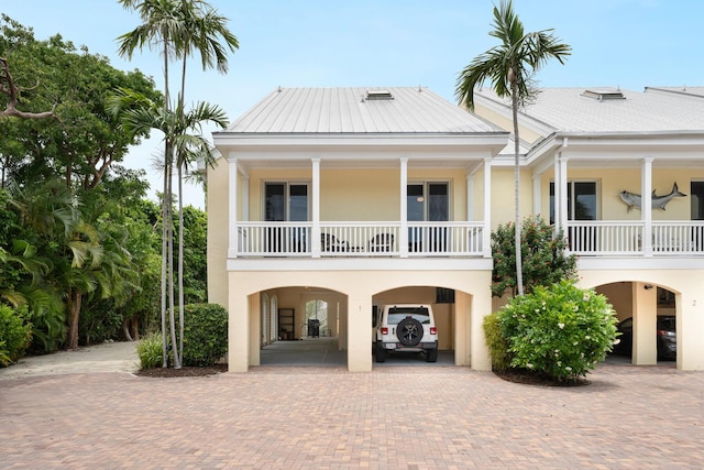 81250 Overseas Hwy Unit 1, Islamorada, FL 33036 - coastal home with a carport, stucco siding, decorative driveway, and a balcony