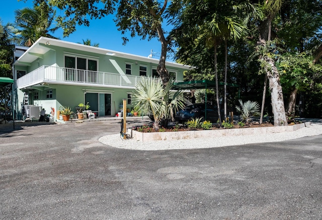 87950 Overseas Hwy, Islamorada, FL 33036 - view of front of house featuring stucco siding, a balcony, and central AC unit