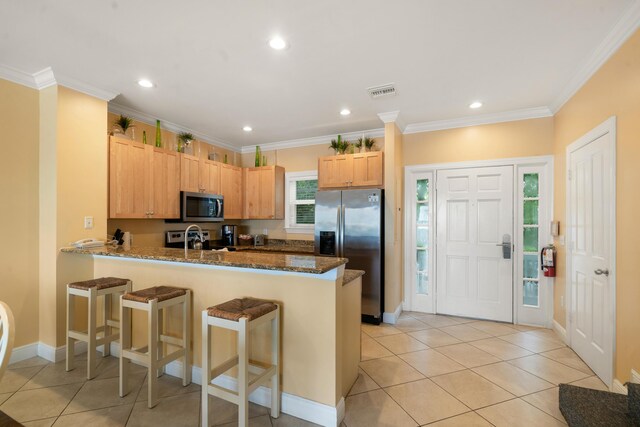2600 Overseas Hwy Unit 87, Marathon, FL 33050 - kitchen featuring crown molding, appliances with stainless steel finishes, a kitchen breakfast bar, kitchen peninsula, and dark stone counters