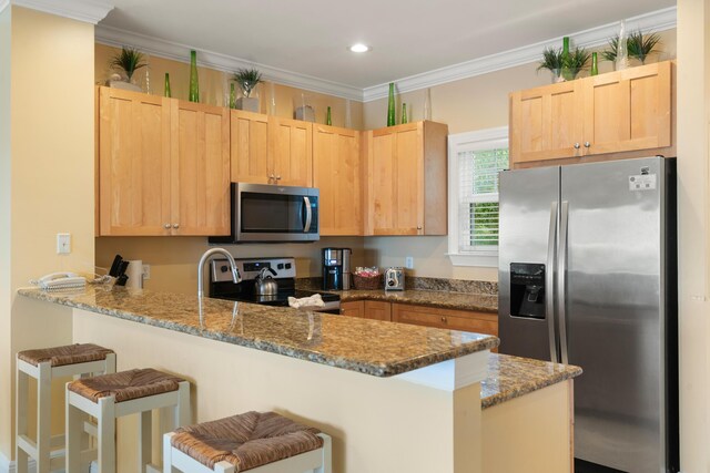 2600 Overseas Hwy Unit 87, Marathon, FL 33050 - kitchen featuring dark stone countertops, light brown cabinets, kitchen peninsula, and appliances with stainless steel finishes