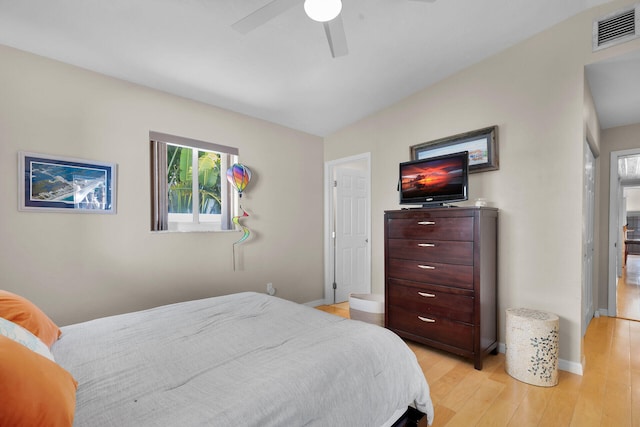 bedroom featuring baseboards, light wood finished floors, visible vents, and a ceiling fan