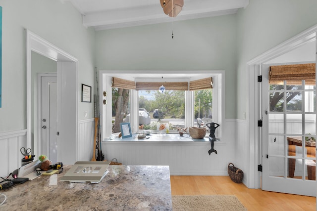 bathroom with beam ceiling, wood finished floors, and wainscoting