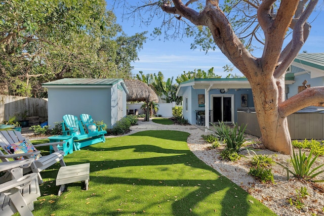 view of yard with an outdoor structure, a storage shed, and a fenced backyard