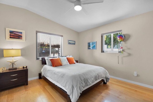 bedroom featuring baseboards, light wood finished floors, a ceiling fan, and vaulted ceiling