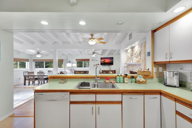 kitchen with a sink, beam ceiling, dishwasher, light countertops, and a ceiling fan