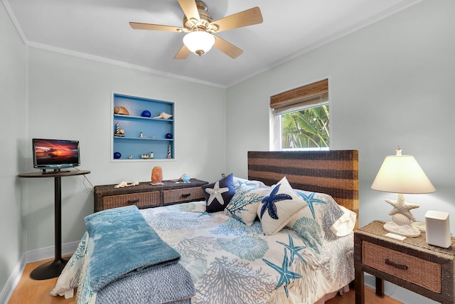 bedroom featuring baseboards, crown molding, a ceiling fan, and wood finished floors