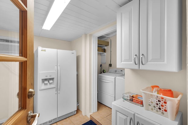 laundry area featuring light tile patterned floors, washer and dryer, and cabinet space