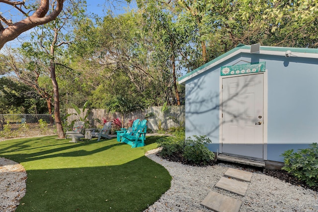 view of yard featuring a fenced backyard, an outdoor structure, and a storage shed