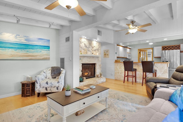 living room featuring light wood-style floors, visible vents, and ceiling fan