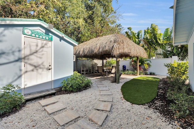 view of outdoor structure featuring outdoor dining space, an outdoor structure, and a fenced backyard