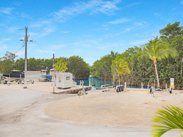 view of property's community featuring a water view and a shed