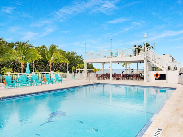 view of pool with a patio and a water view