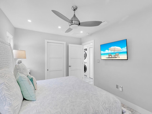 bedroom featuring stacked washer and dryer and ceiling fan