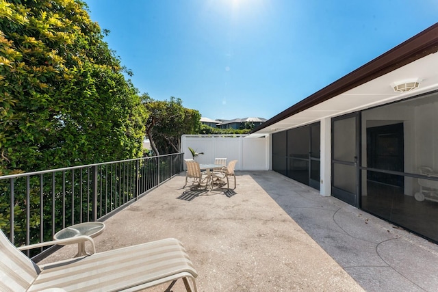 view of patio featuring a balcony and outdoor dining space