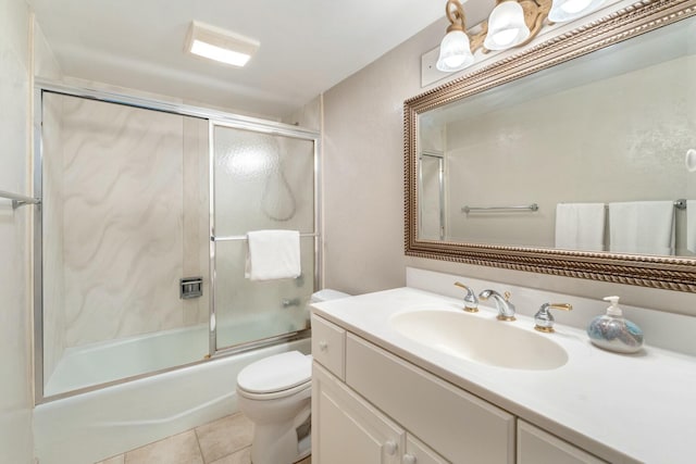 bathroom with shower / bath combination with glass door, toilet, vanity, and tile patterned flooring