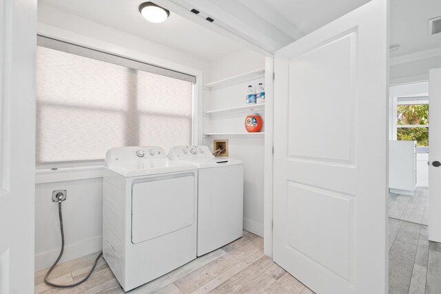 laundry area featuring washing machine and dryer and light wood-type flooring