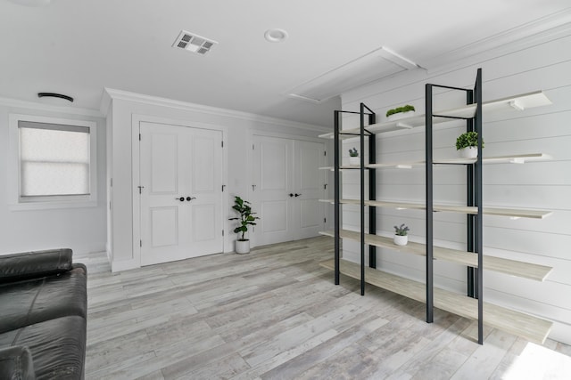 foyer with ornamental molding and light hardwood / wood-style flooring