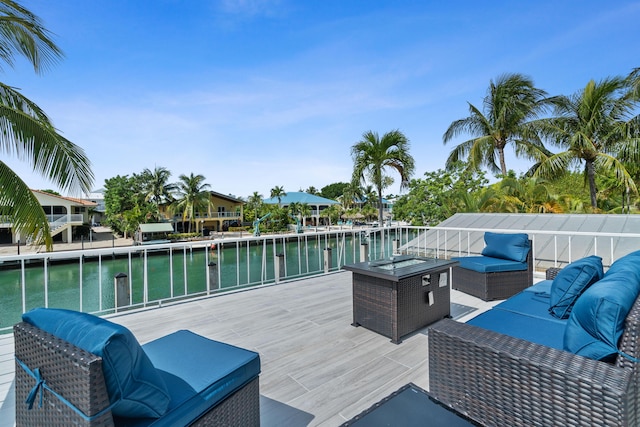 deck with an outdoor living space and a water view