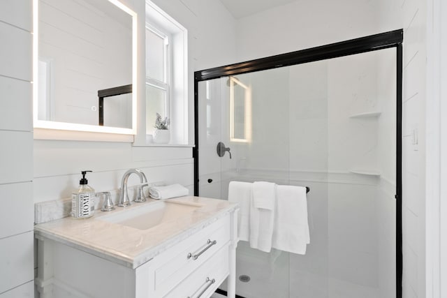 bathroom with a shower with door and vanity