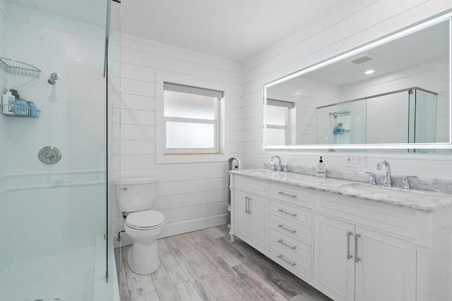 bathroom featuring hardwood / wood-style flooring, vanity, toilet, and an enclosed shower