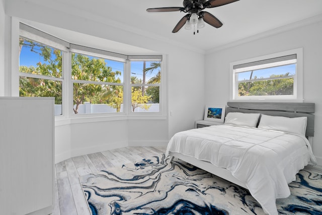bedroom with crown molding, ceiling fan, and hardwood / wood-style floors