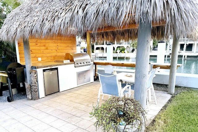view of patio with a gazebo, an outdoor kitchen, a grill, and exterior bar