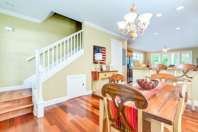 dining area featuring ornamental molding, wood-type flooring, and ceiling fan with notable chandelier