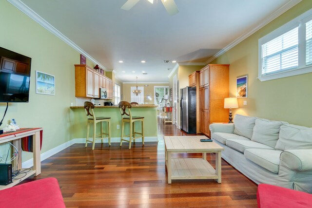 living room featuring crown molding, dark wood-type flooring, and ceiling fan