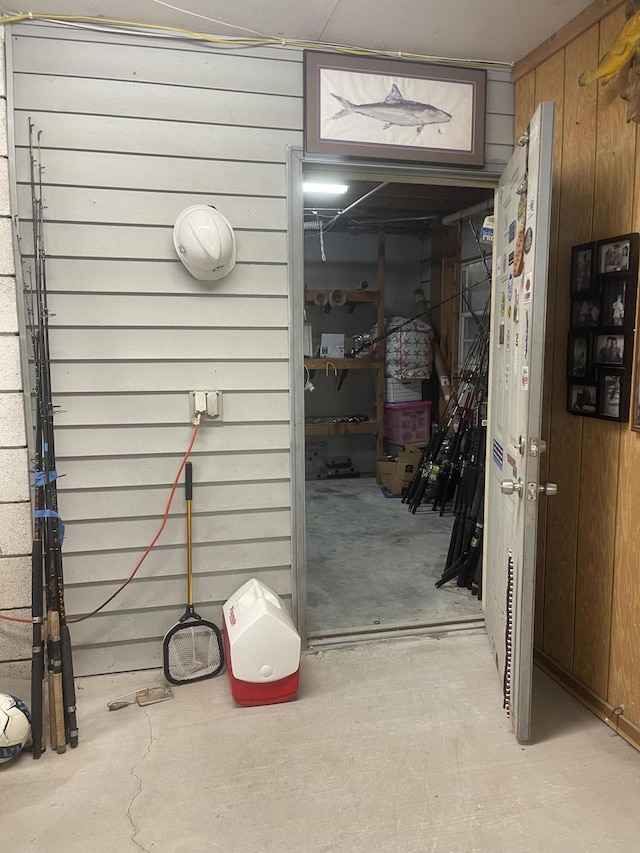 basement featuring wooden walls