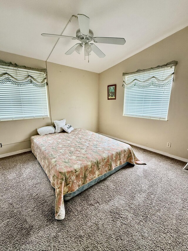 bedroom with ceiling fan, carpet flooring, and multiple windows