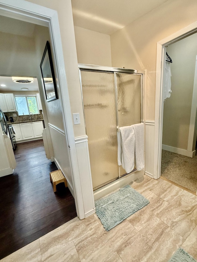 bathroom featuring a shower with door, vanity, and hardwood / wood-style flooring