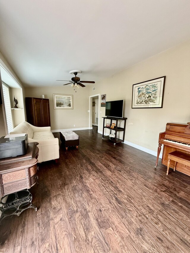 living room featuring ceiling fan and dark hardwood / wood-style flooring