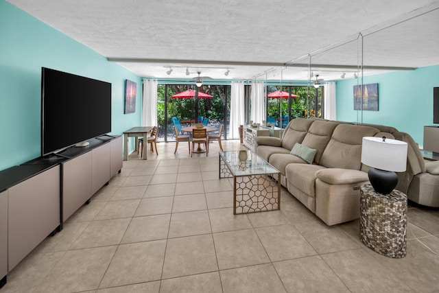 living area featuring track lighting, light tile patterned flooring, and a textured ceiling