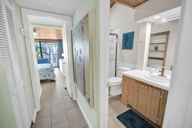 bathroom featuring a closet, tile patterned flooring, vanity, a stall shower, and toilet