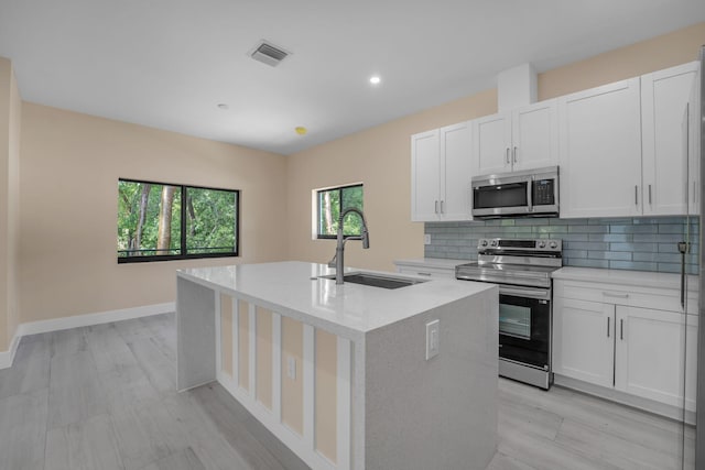 793 Oceana Ave, Key Largo, FL 33037 - kitchen with appliances with stainless steel finishes, an island with sink, backsplash, white cabinets, and recessed lighting