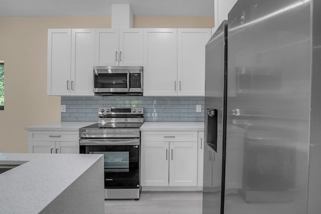 793 Oceana Ave, Key Largo, FL 33037 - kitchen with appliances with stainless steel finishes, white cabinets, and tasteful backsplash