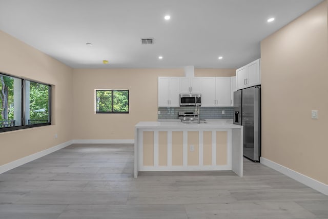 793 Oceana Ave, Key Largo, FL 33037 - kitchen featuring appliances with stainless steel finishes, light countertops, white cabinets, light wood-style flooring, and recessed lighting