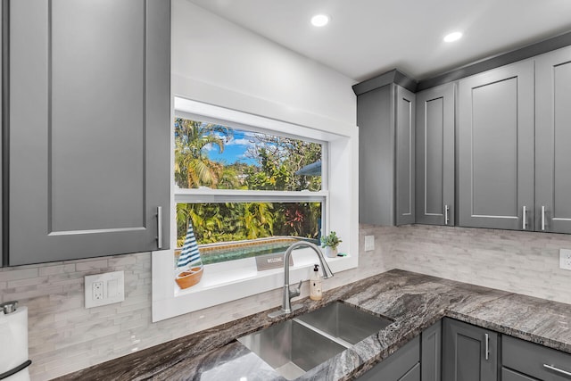 1519 Johnson St, Key West, FL 33040 - kitchen featuring backsplash, dark stone counters, sink, and gray cabinetry